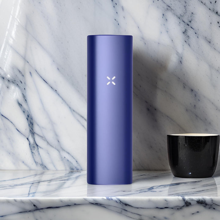 vaporizador herbal portable pax plus color azul sobre mesa